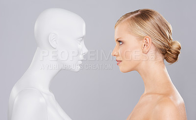 Buy stock photo Studio, woman and mannequin with beauty clone versus artificial standard, perfect and facial wellness. Girl, doll and face in profile for cosmetics, plastic surgery or makeup on grey background.