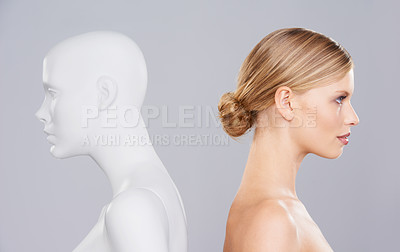 Buy stock photo Studio, woman and profile of mannequin with beauty versus artificial standard, perfect and facial wellness. Girl, doll and clone of face for cosmetics, plastic surgery or makeup on grey background.