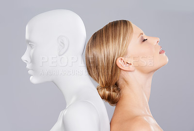 Buy stock photo Studio, girl and mannequin with perfect beauty versus artificial standard, identity and facial wellness. Woman, doll and face in profile for cosmetics, plastic surgery or makeup on grey background.