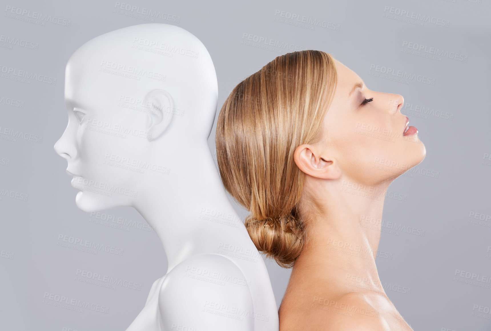 Buy stock photo Studio, girl and mannequin with perfect beauty versus artificial standard, identity and facial wellness. Woman, doll and face in profile for cosmetics, plastic surgery or makeup on grey background.