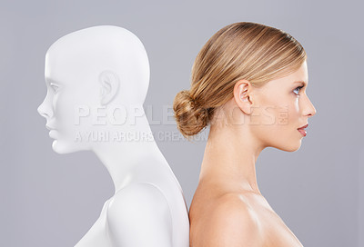 Buy stock photo A beautiful young woman standing back to back with a mannequin
