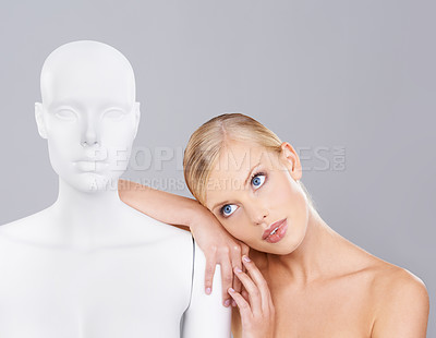Buy stock photo Woman, beauty and relax with mannequin, thinking and unique skincare with wellness on white background. Inspiration, natural cosmetics and dermatology with individuality, robot or dummy in studio