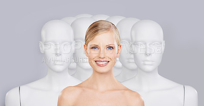 Buy stock photo A young woman standing amongst a group of mannequins