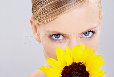 Buy stock photo Portrait, skincare and woman with sunflower, wellness or dermatology on a white studio background. Face, person or model with shine or makeup with natural cosmetics or beauty with aesthetic or luxury