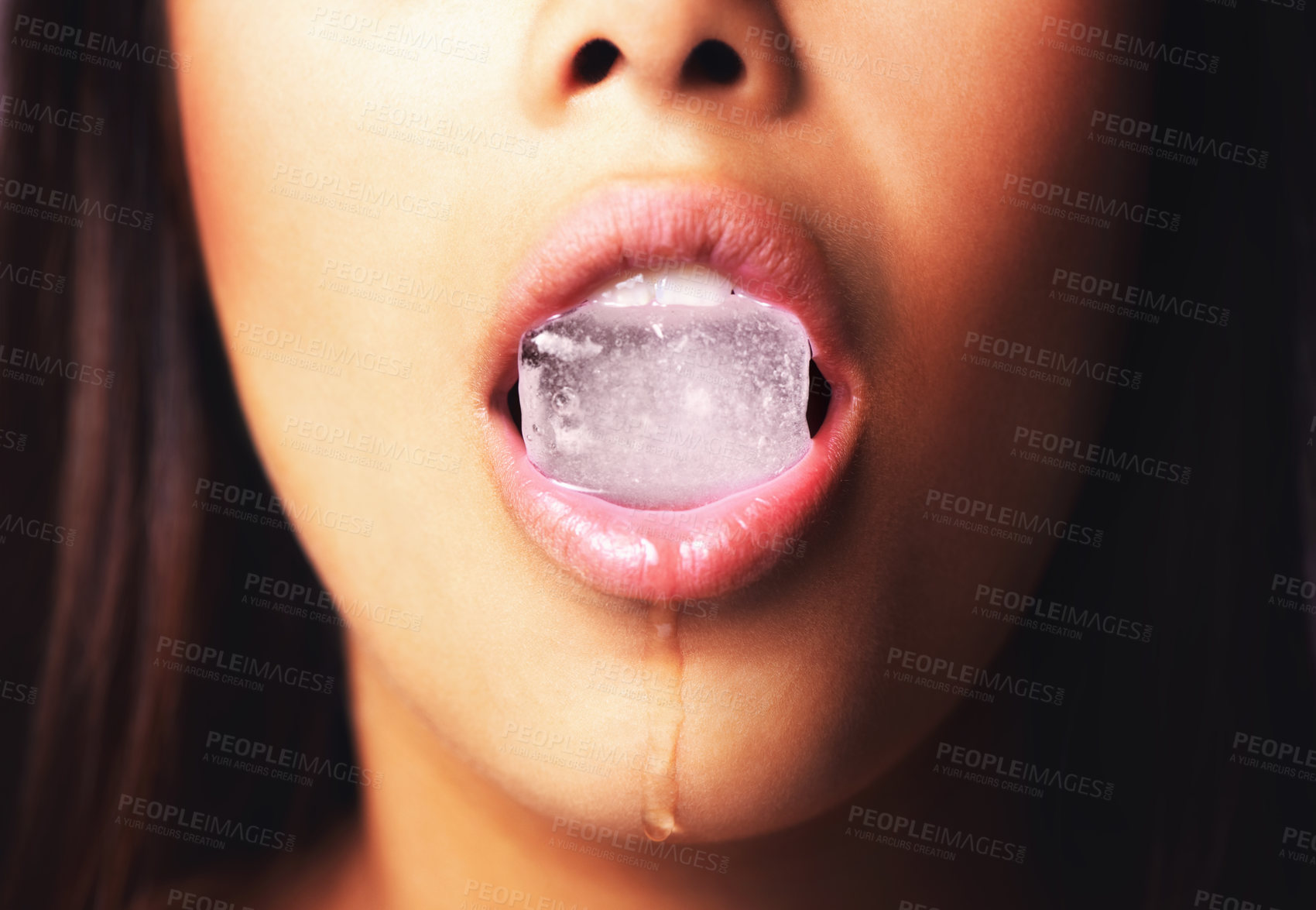 Buy stock photo Shot of a woman holding an ice block in her mouth