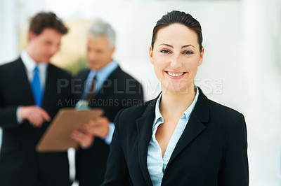 Buy stock photo Woman, portrait and colleagues in background of office with smile for business of corporate company. Person, happy and  professional as employee with suit and collaboration with team to work for job