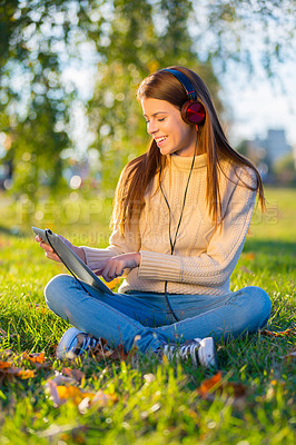 Buy stock photo Woman, headphones and relaxing with music on tablet, streaming radio and podcast in outdoors. Female person, nature and internet for classical playlist on weekend, calm and peaceful song on grass