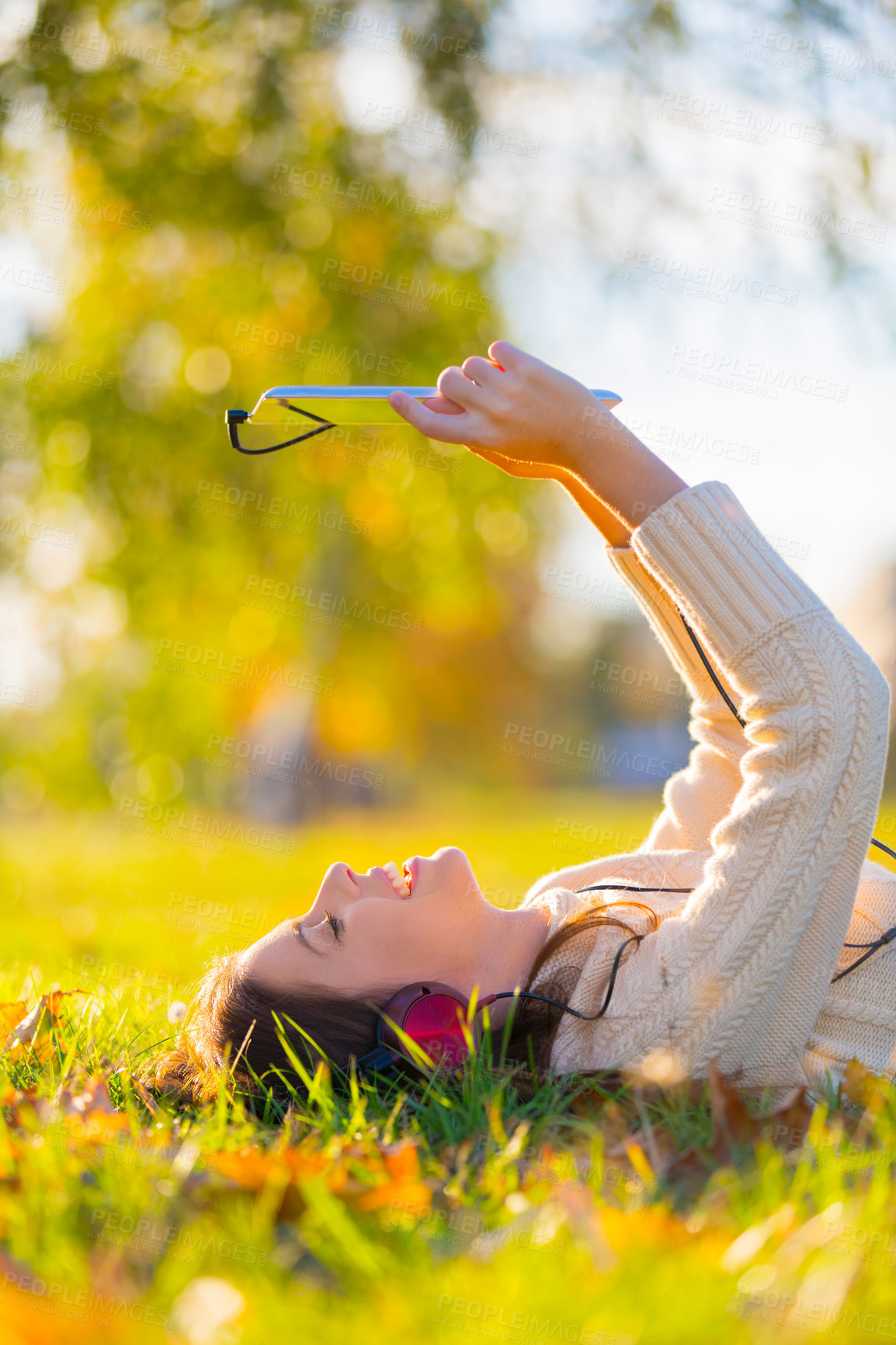 Buy stock photo Woman, headphones and tablet for music on grass, streaming radio and podcast outdoors. Female person, nature and internet for movie subscription on weekend, calm and peaceful playlist on lawn