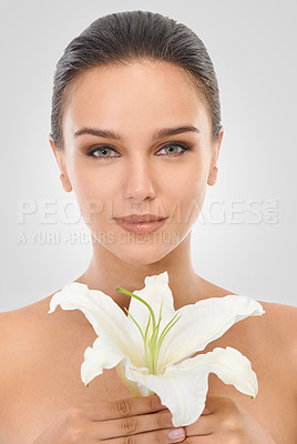 Buy stock photo Makeup, floral and portrait of woman in studio with glamour, glow and cosmetic face routine. Beauty, confident and young female person with flower plant for facial cosmetology by gray background.