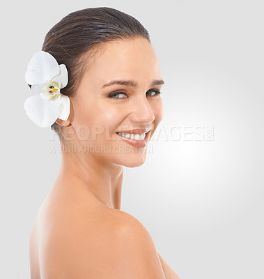 Buy stock photo Girl, portrait and flower with glow for skincare in studio, beauty and natural makeup for blossom. Woman, orchid and hair with background, face and closeup with cosmetics dermatology for wellness