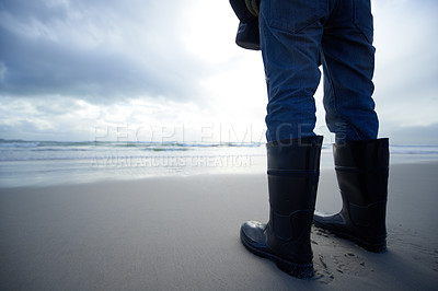 Buy stock photo Travel, boots and shoes of person at beach for ocean, tourism and walking in sand. Adventure, vacation and calm with feet of traveler and gumboots at seaside for relax, holiday trip and journey