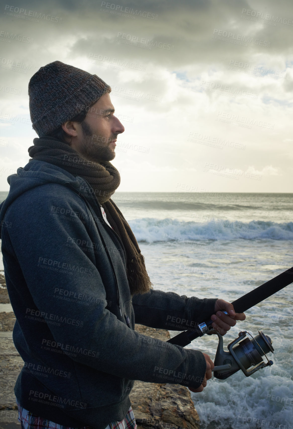 Buy stock photo Fishing, relax and travel with man at beach for adventure, holiday and hobby break. Sunset, calm and patience with male fisherman and casting rod pole in nature for recreation, view and vacation