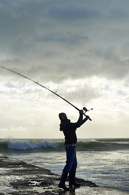 Buy stock photo Fishing rod, casting and man at a beach for water hobby, recreation or stress relief in nature. Pole, line and male fisherman at the ocean for travel, journey or fish sports adventure in Cape Town