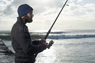 Buy stock photo Night, fishing and man at a beach with pole for water hobby, recreation or stress relief vacation in nature. Casting, rod and male fisherman at sea for travel, adventure or fisher sports in Cape Town