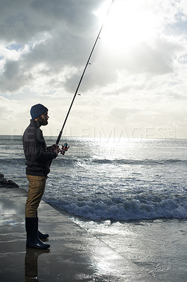 Buy stock photo Thinking, fishing and man at a beach with pole for water hobby, recreation or stress relief vacation in nature. Casting, rod and fisherman at sea for travel, adventure or fisher sports in Cape Town