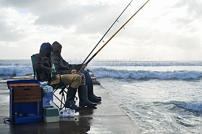 Buy stock photo Ocean, fishing rod and men outdoor in winter, leisure activity at beach or harbor with friends in nature for seafood. Travel, seascape and waves with fisherman, recreation or hobby in the cold