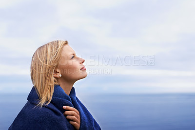 Buy stock photo Thinking, ocean and woman with blanket with blue sky for adventure on holiday, vacation and weekend outdoors. Nature, travel and person by seaside for relaxing, happiness and peace in countryside