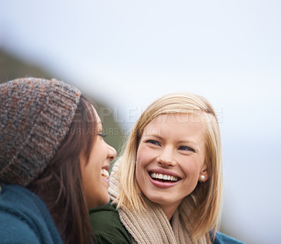 Buy stock photo Two young women sitting together outside