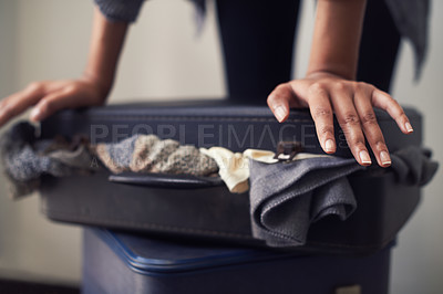 Buy stock photo A woman trying to close an over-full suitcase