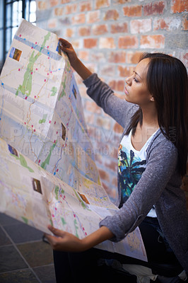 Buy stock photo A young woman reading a map