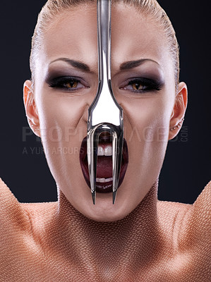 Buy stock photo Shot of a woman with a fork in front of her face imitating a snake