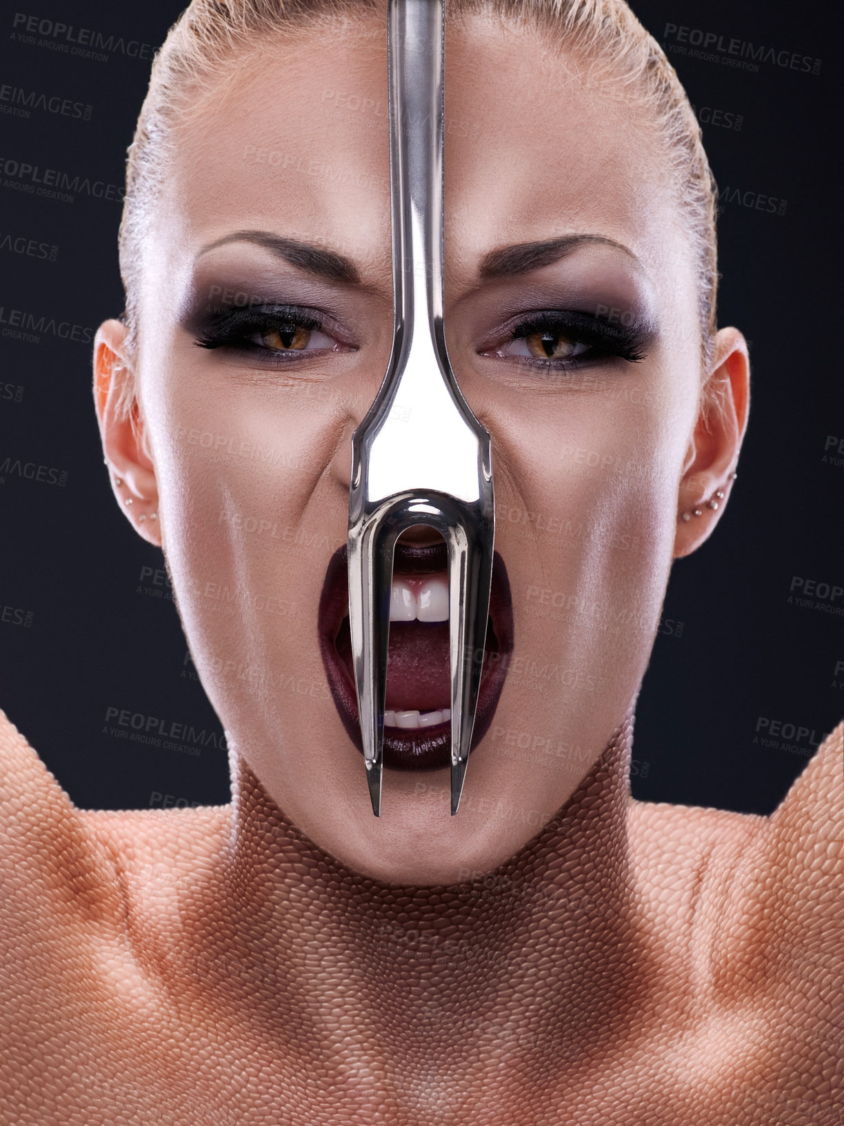 Buy stock photo Shot of a woman with a fork in front of her face imitating a snake