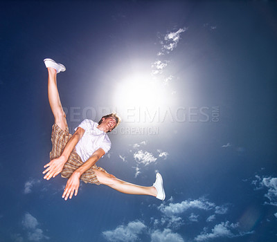 Buy stock photo Boy, blue sky and jump outdoor with low angle, energy and lens flare of sunshine. Young teenager, below and leap in air by clouds in summer, moving and kid screaming for freedom with agile action