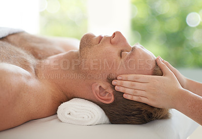 Buy stock photo Shot of a handsome man getting a head massage at a spa