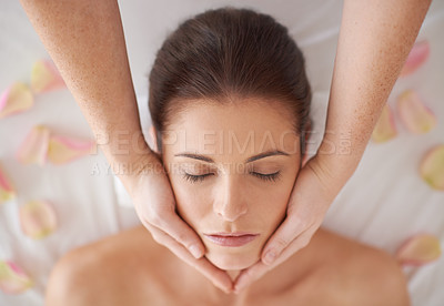 Buy stock photo Hands, above and massage face of woman at spa to relax, peace and calm for aromatherapy with organic flowers. Top view, therapy and person at salon for facial treatment, skincare or beauty for health