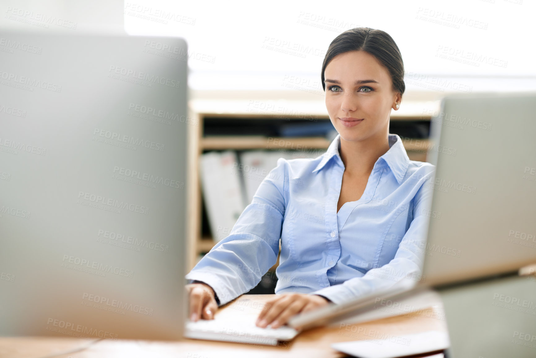 Buy stock photo Shot of a young office professional working at a computer