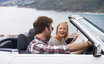 Buy stock photo Shot of a young couple enjoying a drive along the coast in a convertible