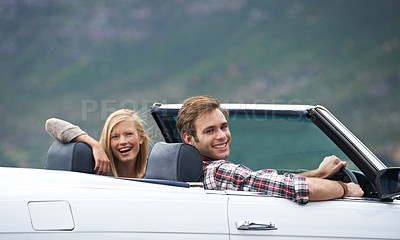 Buy stock photo A young couple driving in a convertible on a road trip