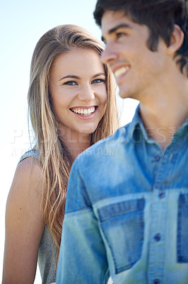 Buy stock photo A smiling young woman standing behind her boyfriend
