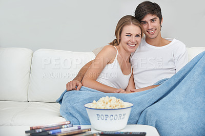 Buy stock photo A young couple watching a movie at home