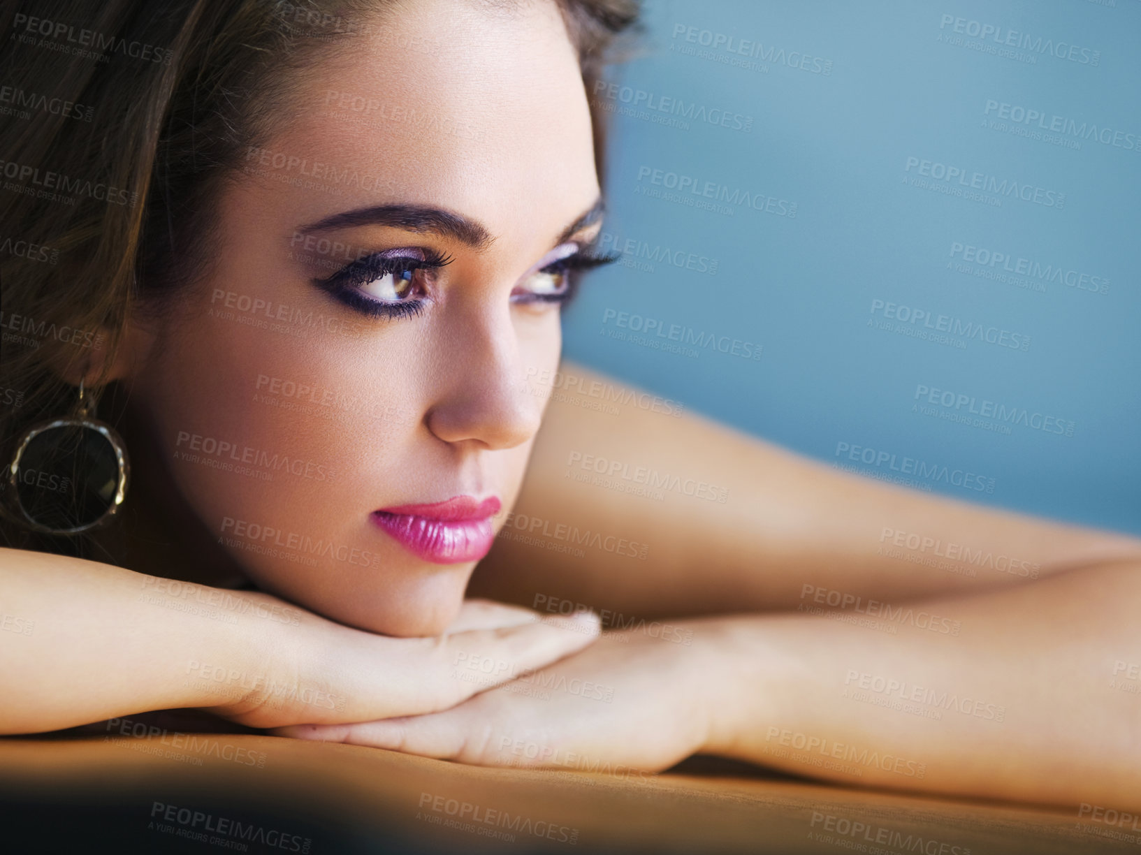 Buy stock photo Head shot of an attractive woman resting her head on her hands and looking away