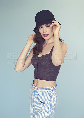 Buy stock photo Fashion, portrait and a young woman in studio with a hat, cool style and trendy clothes. Gen z female model person on a grey background for retro beauty, confidence and stylish casual outfit