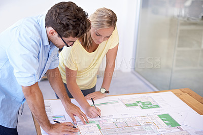 Buy stock photo Two architects discussing elements of an architectural plan