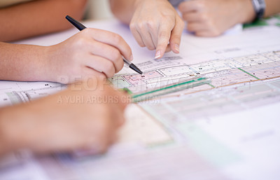 Buy stock photo Cropped shot of a group of architects reviewing blueprints