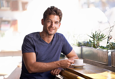 Buy stock photo A young man enjoying a cup of coffee in a coffee shop