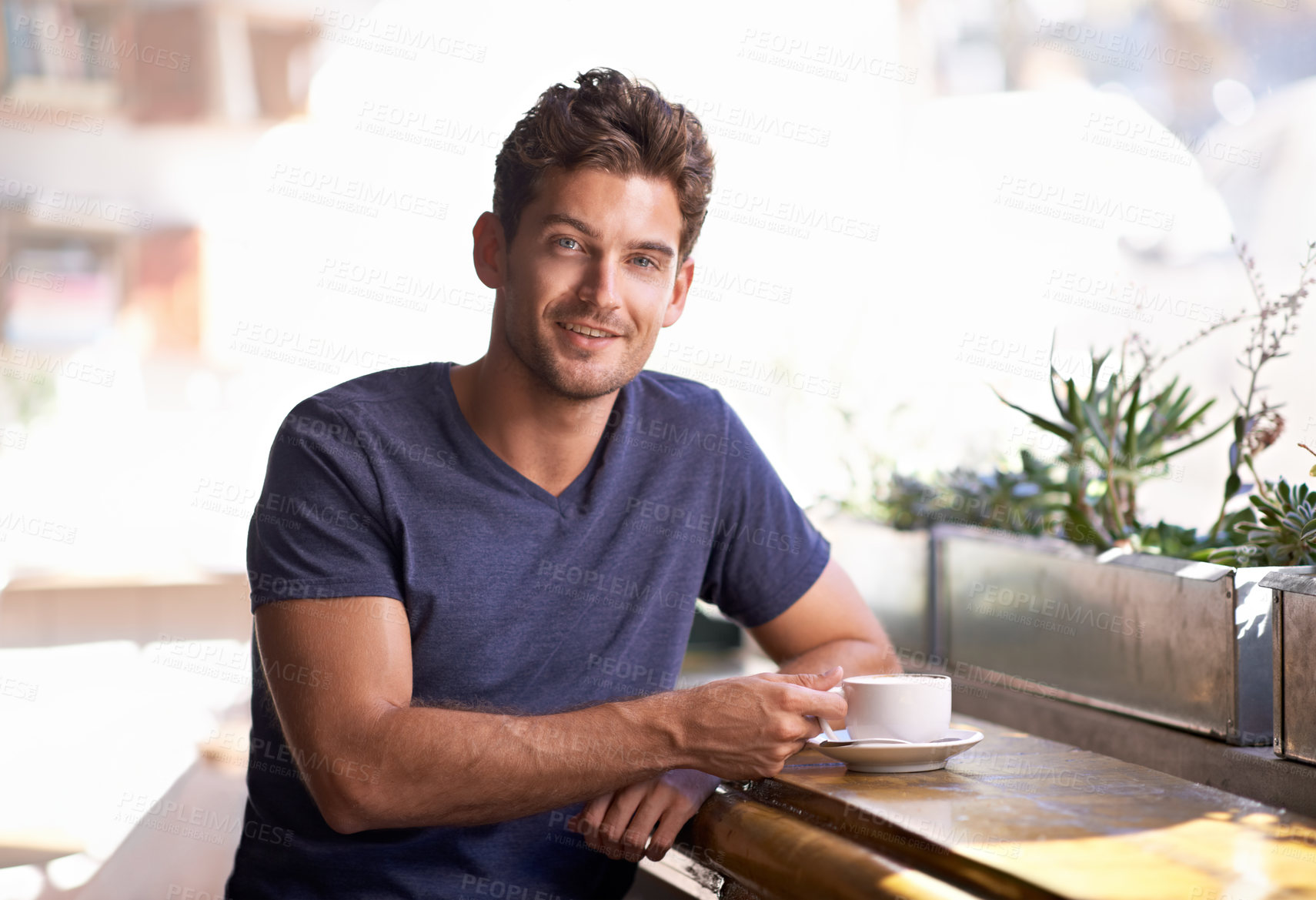 Buy stock photo A young man enjoying a cup of coffee in a coffee shop