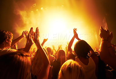 Buy stock photo Music, concert and crowd with light, clapping for live performance, rock event and band on stage at night. People, audience and music festival, audio and sound with energy at show with musical artist