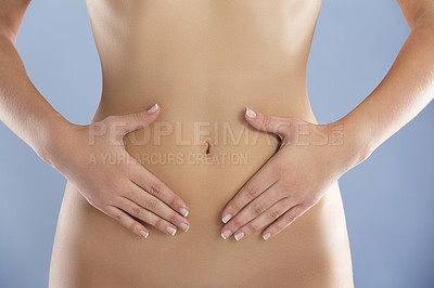 Buy stock photo Health, diet and hands on stomach of woman for wellness, lose weight and digestion on blue background. Weightloss, liposuction and abdomen closeup of female person for healthy gut, fitness and care