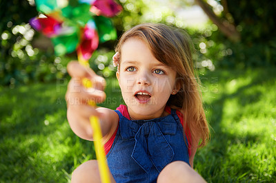 Buy stock photo Toy, girl and child playing with windmill on grass in nature, relax and having fun on lawn outdoor. Park, garden and young kid with pinwheel on summer vacation closeup for recreation, game or leisure