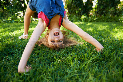 Buy stock photo Child, back and bend or bridge or outdoor play in summer or flexibility game or practice, fun or backyard. Kid, face and excited or gymnastics stretching on grass lawn in London park, happy or garden