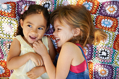 Buy stock photo High angle shot of two little girls lying down and playing on a blanket