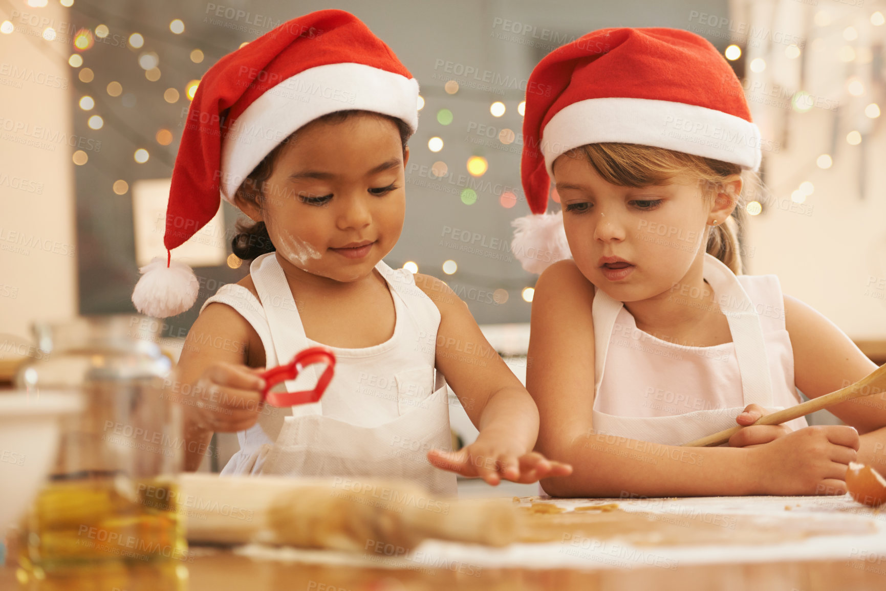 Buy stock photo Kitchen, friends and children baking a christmas cookie, cake or dessert together at their home. Happy, interracial and young girl kids cooking festive, holiday and celebration sweet treats for party