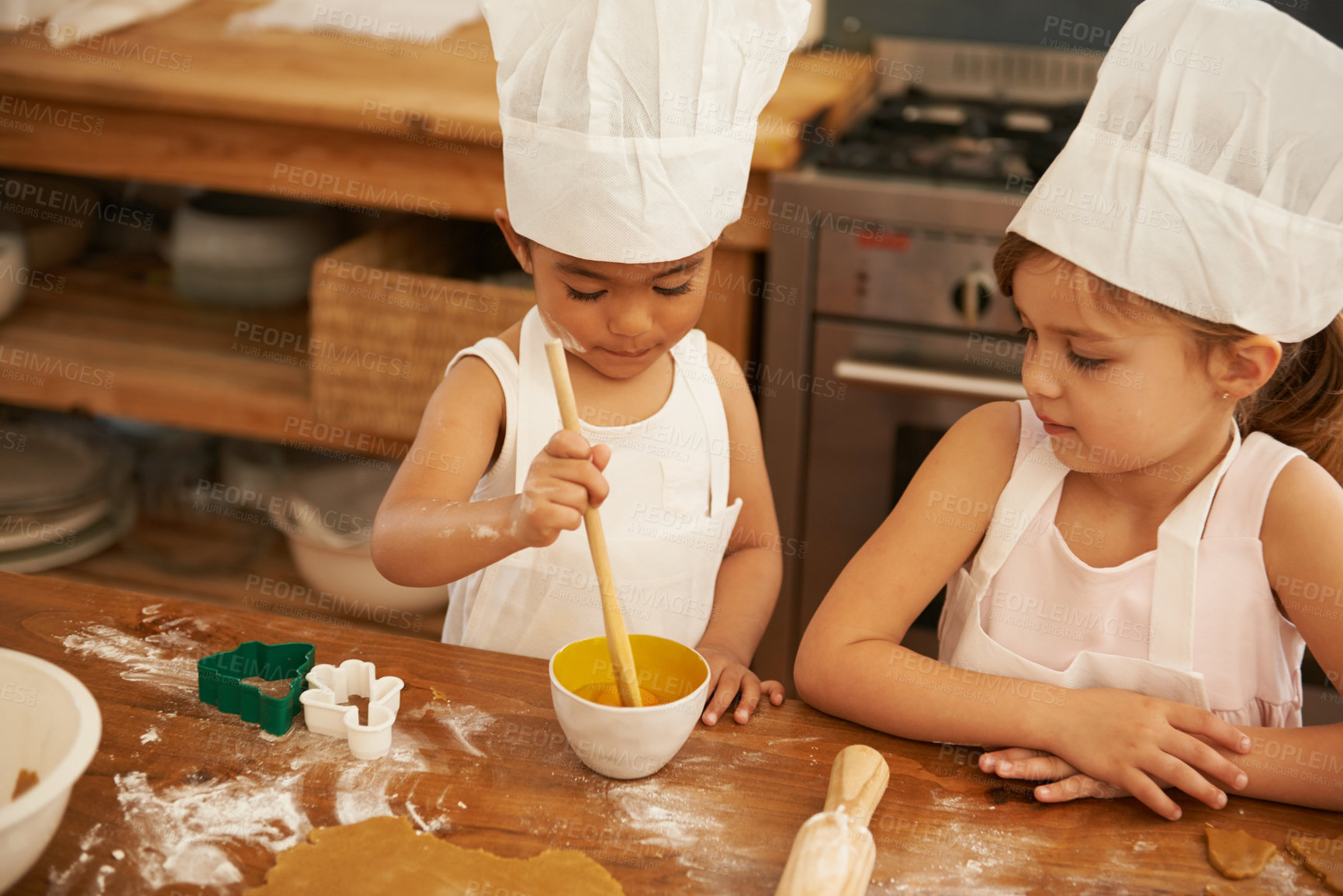 Buy stock photo Children, learning and baking in a kitchen with girls bonding, curious and mixing egg for cake in their home. Kids, cooking and siblings having fun with cookies, recipe and development activity