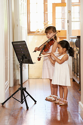 Buy stock photo Full-length shot of two little girls playing violins