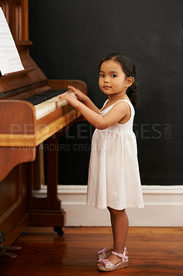 Buy stock photo Cropped shot of a little girl playing the piano