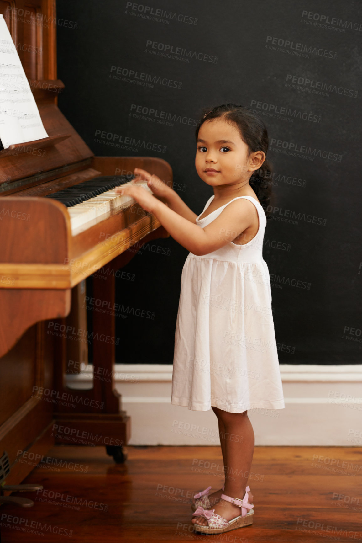 Buy stock photo Cropped shot of a little girl playing the piano